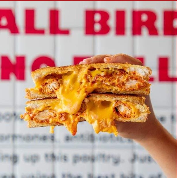 Hand holding a BonBird chicken melt